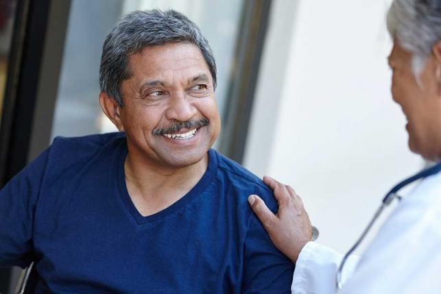 smiling-man-comforted doctor patient health insurance