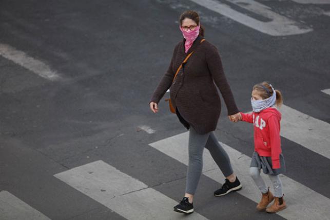 pregnant woman walking with child and masks during COVID-19 outbreak