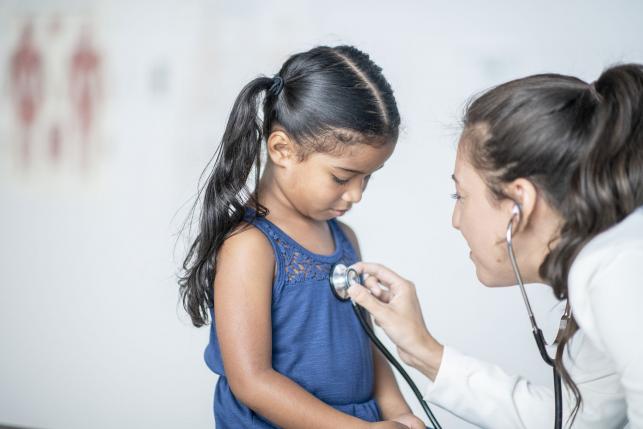 Immigrant child receiving medical treatment from a doctor