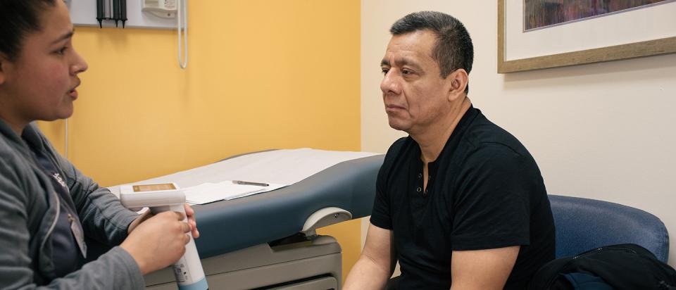 Man sits for an exam by doctor
