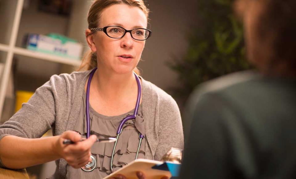 nurse-explains-paperwork-at-clinic doctor patient health insurance
