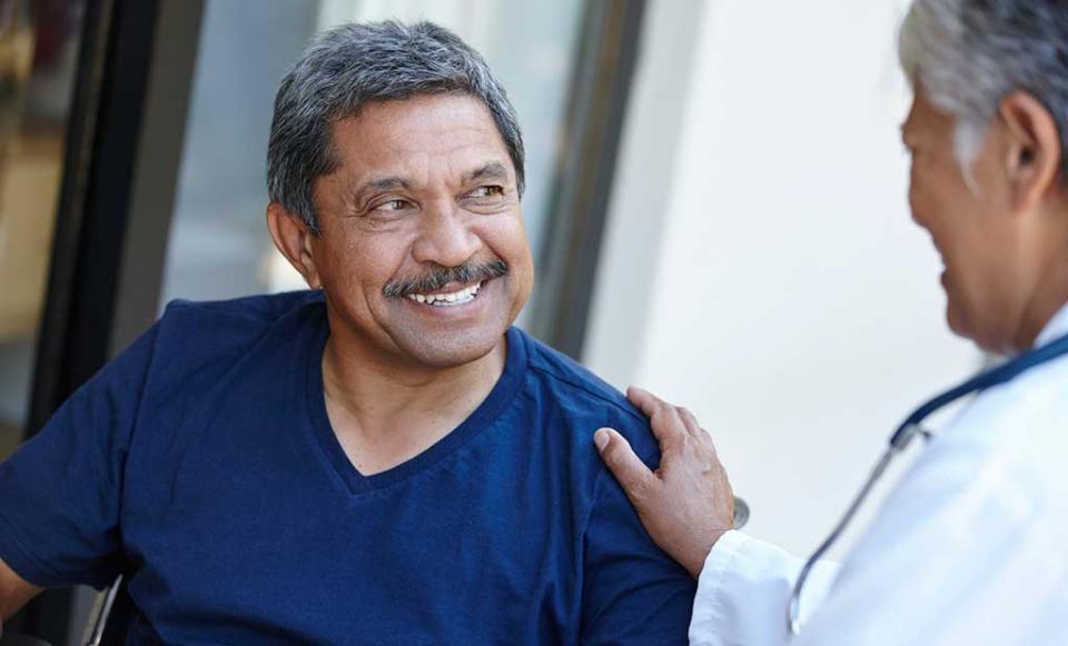 smiling-man-comforted doctor patient health insurance