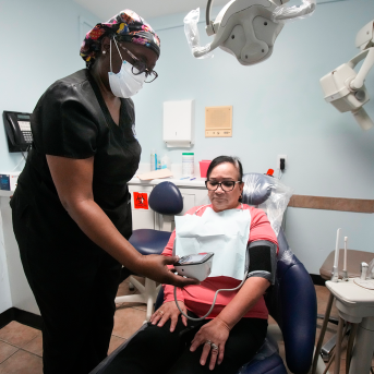 Dental assistant helps client in chair