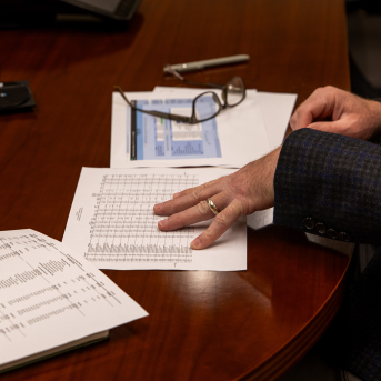 Hand looks at paper work on table