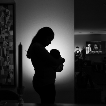 Sillouhette of mother holding baby in hope