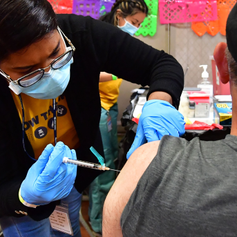 Registered Nurse Mariam Salaam administers the Pfizer booster shot at a Covid vaccination and testing site in Los Angeles on May 5, 2022. A fall booster vaccination campaign could drastically reduce Covid-19 deaths and hospitalizations this winter.