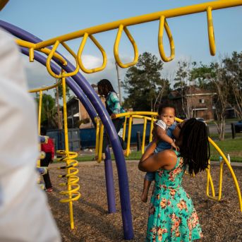 Shell Reed plays with her children on a playscape at Cuney Homes in Houston’s Third Ward