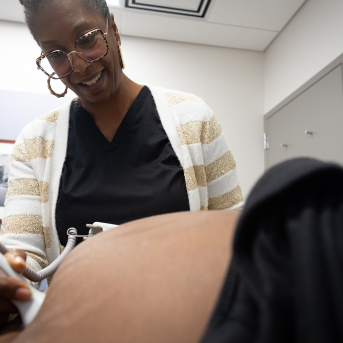 Midwife performs ultrasound on pregnant woman