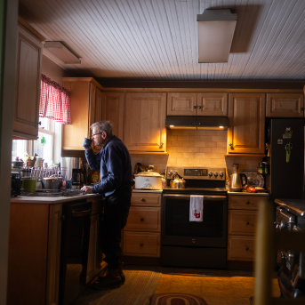 Man looks out window in his kitchen