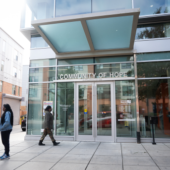 Pregnant patients walk in front of community health center entrance