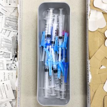 Alcohol swabs, vaccine needles, and bandages on a table