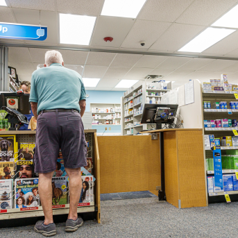 Photo, back of man at drug store counter