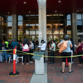 People wait in line in front of building