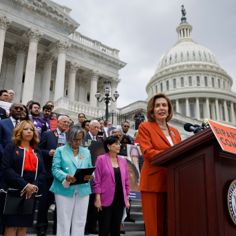 Nancy Pelosi stands in front of U.S. Capitol and other lawmakers