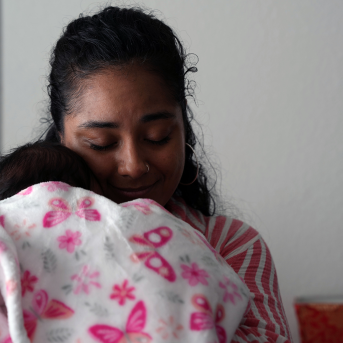 Doula snuggles baby in blanket