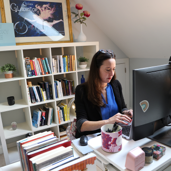 Woman sits at desk in home office