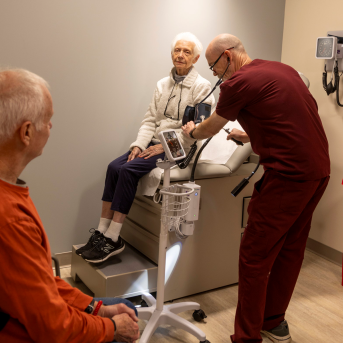 Elderly woman sits on exam table