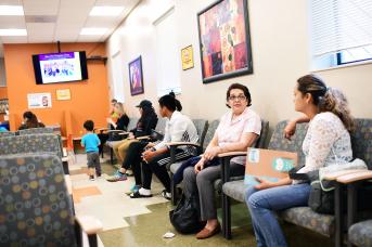 Patients sitting in a free health clinic waiting room.