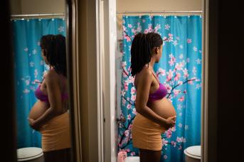 Pregnant person stands in bathroom in Texas
