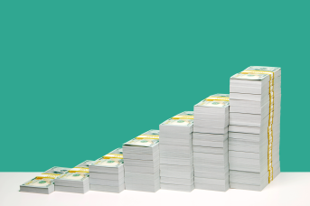 Stacks of U.S. hundred dollar bill bundles in ascending order on white shelf, green background.