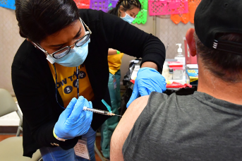 Registered Nurse Mariam Salaam administers the Pfizer booster shot at a Covid vaccination and testing site in Los Angeles on May 5, 2022. A fall booster vaccination campaign could drastically reduce Covid-19 deaths and hospitalizations this winter.