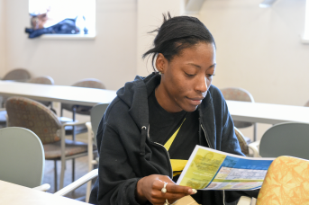 Photo, woman reading pamphlet