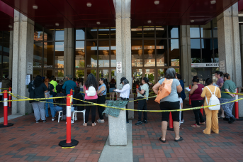 People wait in line in front of building