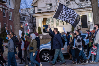 A man waves a Black Lives Matter flag as people march during the "Asian Solidarity March" rally against anti-Asian hate in response to recent anti-Asian crime on March 18, 2021, in Minneapolis.
