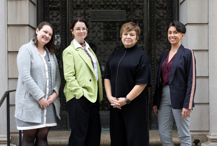 Four women posing for a photo standing in front of the Commonwealth Fund building