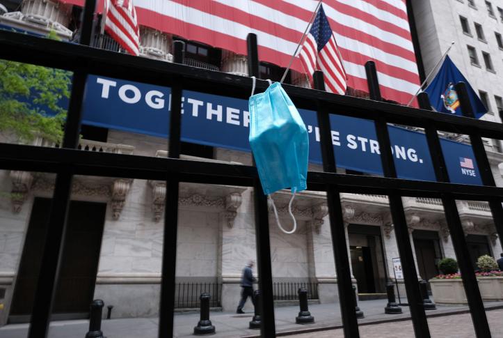 Health Care in 2020 Year in Review face mask hanging in front of the New York Stock Exchange