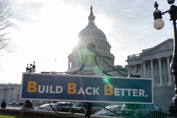 Build Back Better sign sits in front of capitol building for press conference