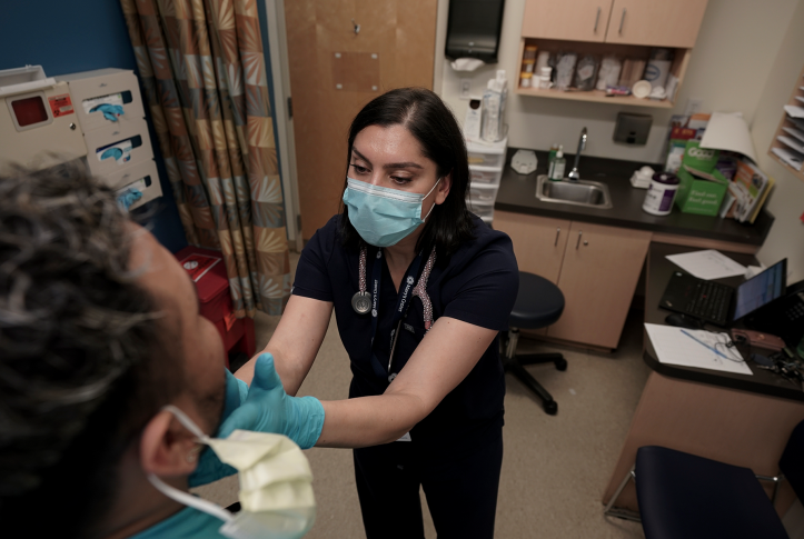 Photo, Doctor examines patients throat with her gloved hands.