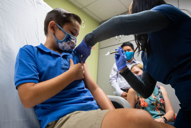 Child receiving vaccine from gloved health care provider