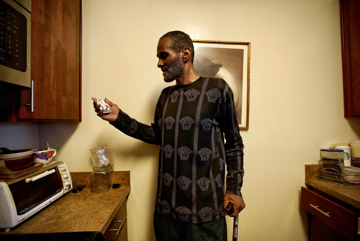 Man holds narcan with cane