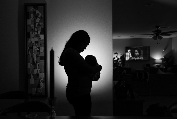 Sillouhette of mother holding baby in hope