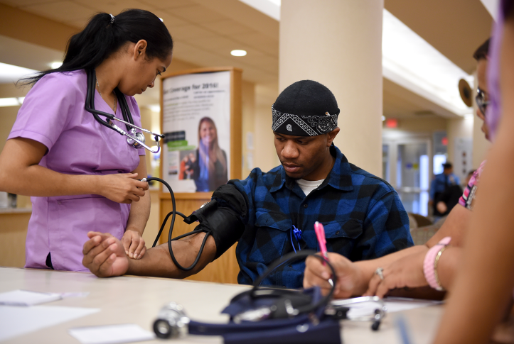 Photo, man gets blood pressure taken by nurse