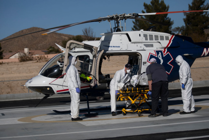 Medical workers load patient onto emergency ambulance