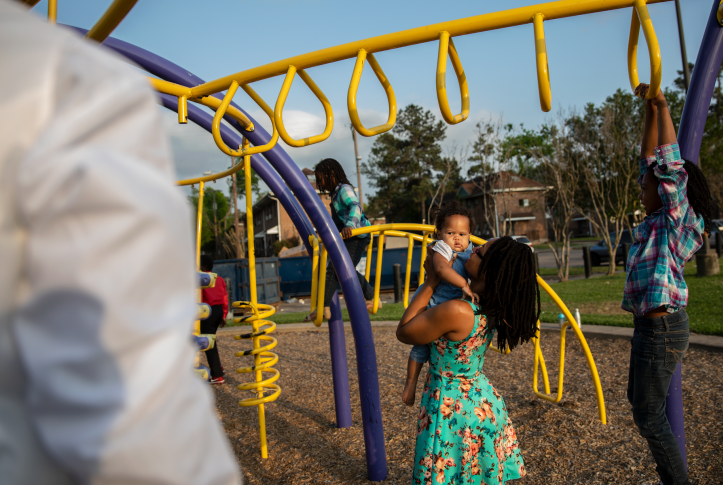 Shell Reed plays with her children on a playscape at Cuney Homes in Houston’s Third Ward 