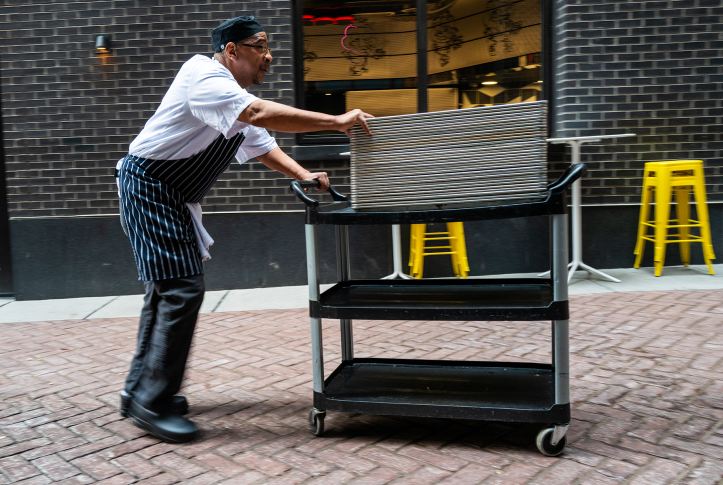 Man in apron pushes cart