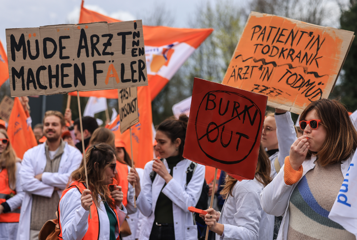 Doctors hold signs protesting in street