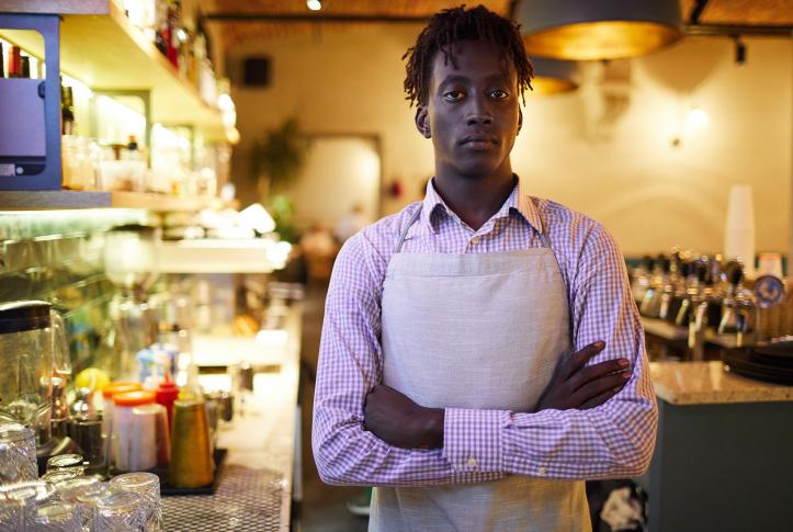 Restaurant worker in an apron at his place of employment.