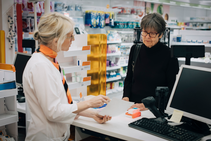 Pharmacist and patient discussing prescription drugs