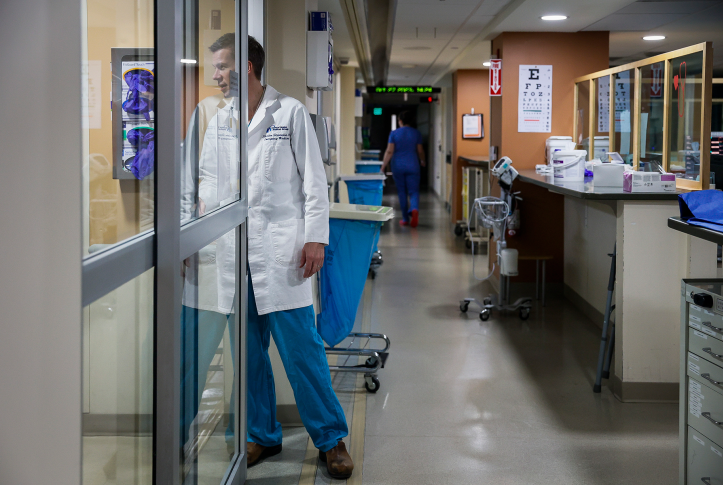 Photo, doctor looks inside room in ER