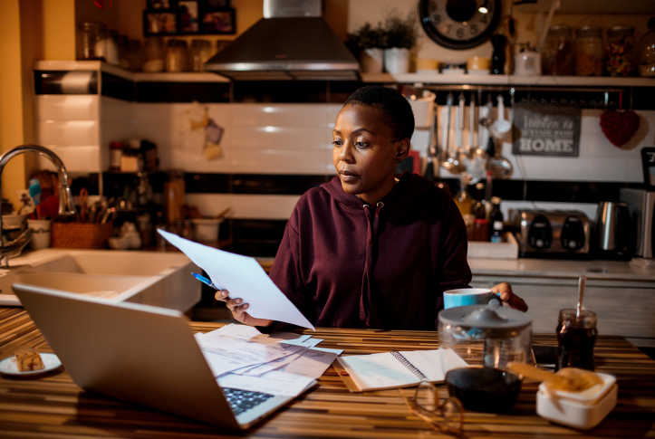 woman looks at paperwork in kitchen