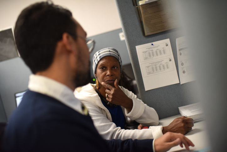 Woman talks to health insurance navigator at desk