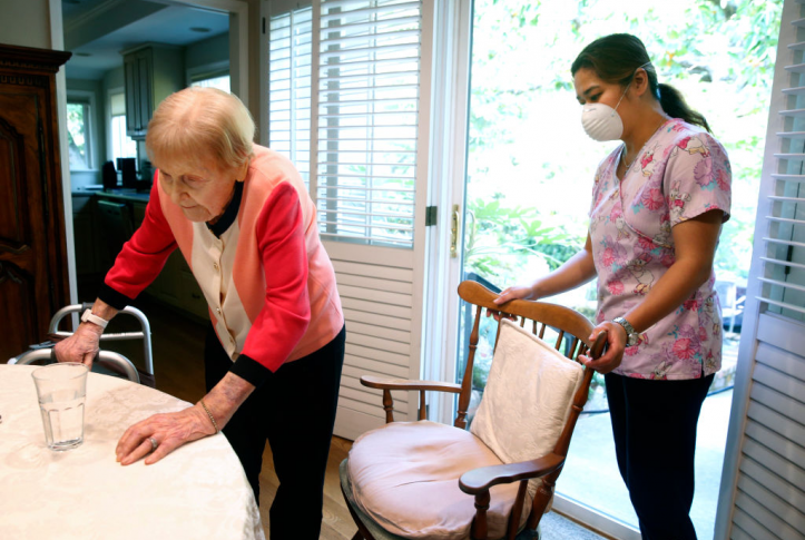 Home health aide helps patient in their home