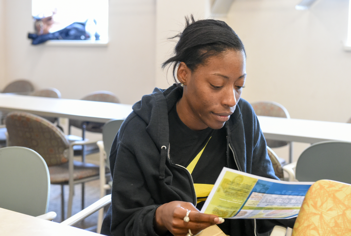 Photo, woman reading pamphlet