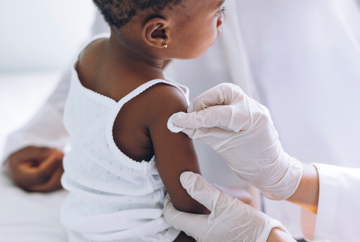 Image, young child getting vaccine from gloved doctor hands