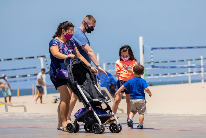A family walks near Hermosa Plaza at the beach in Hermosa Beach, CA.