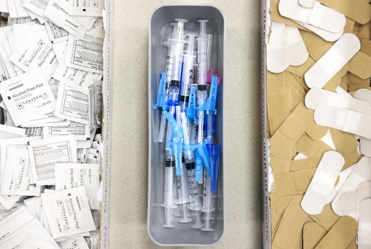 Alcohol swabs, vaccine needles, and bandages on a table